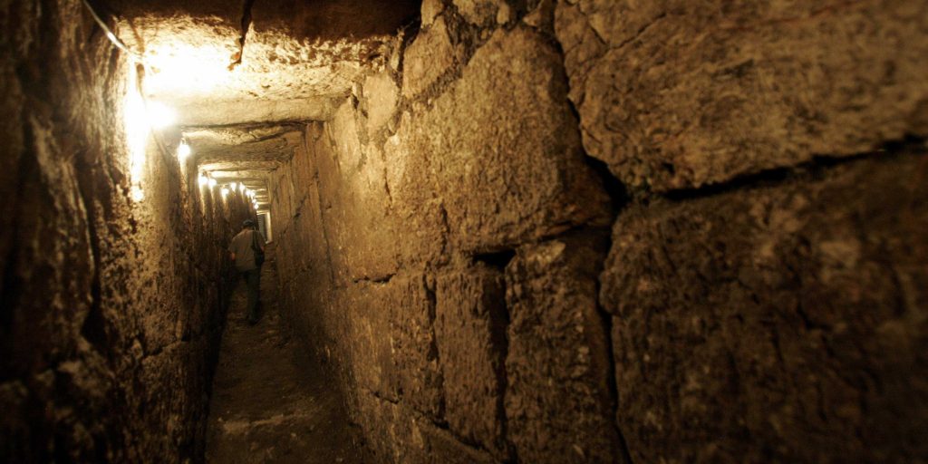 A stone wall in the middle of an underground tunnel.
