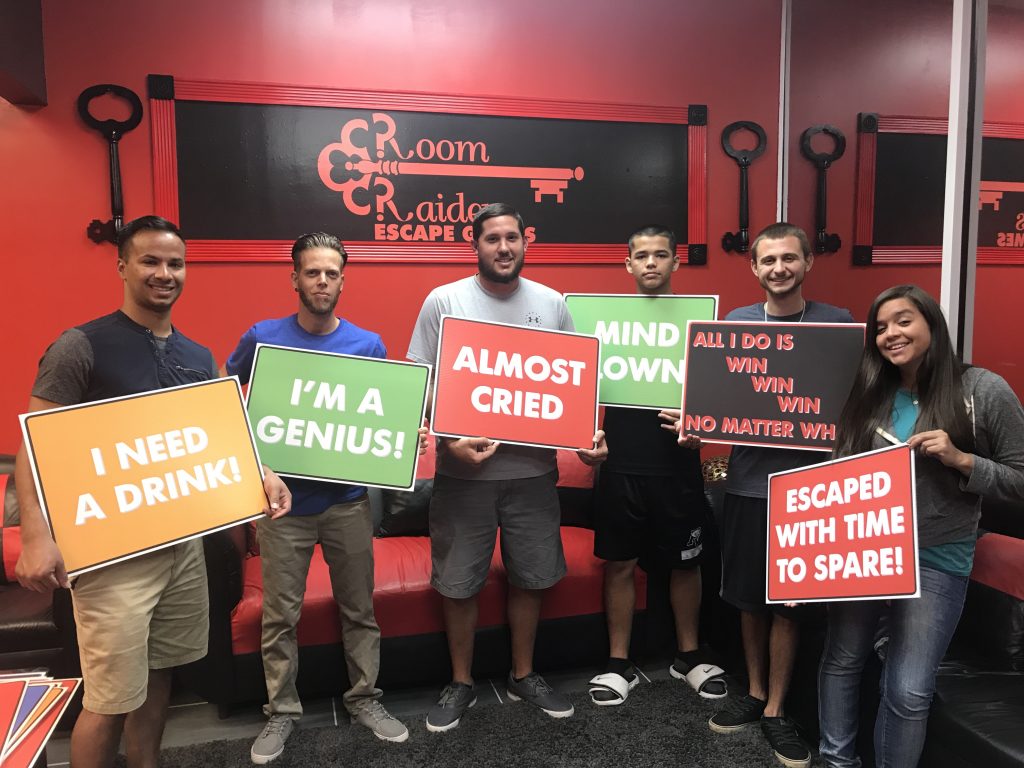 A group of people holding signs in front of a wall.