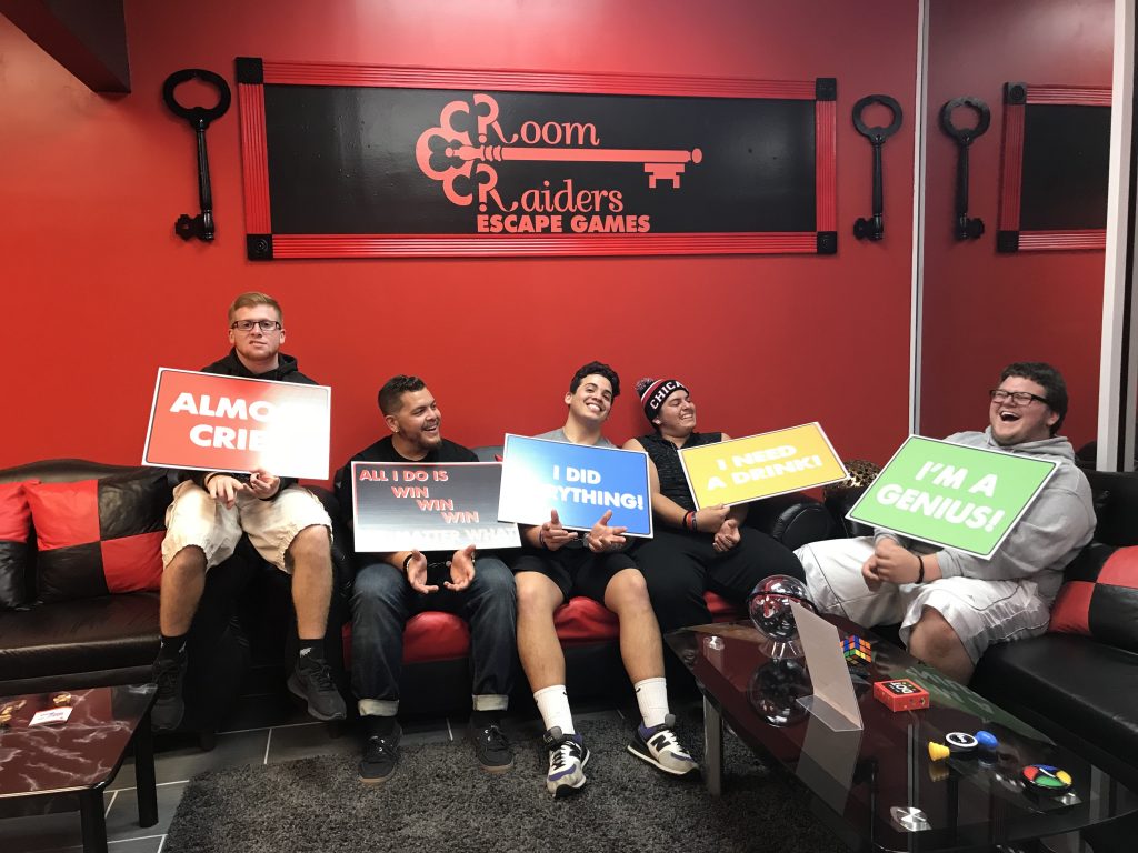 A group of people holding signs in front of a wall.