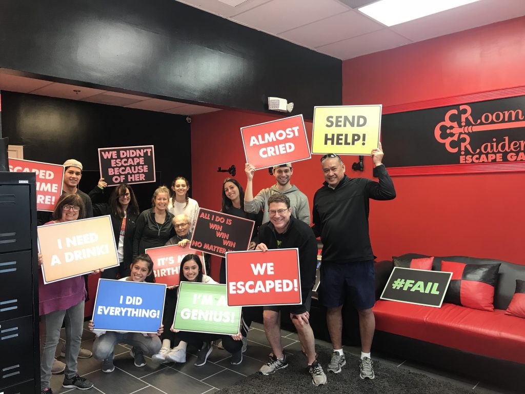 A group of people holding signs in front of a wall.