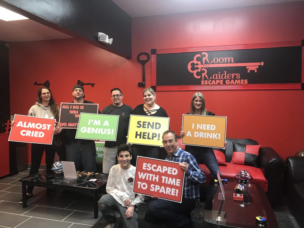 A group of people holding signs in front of a red wall.