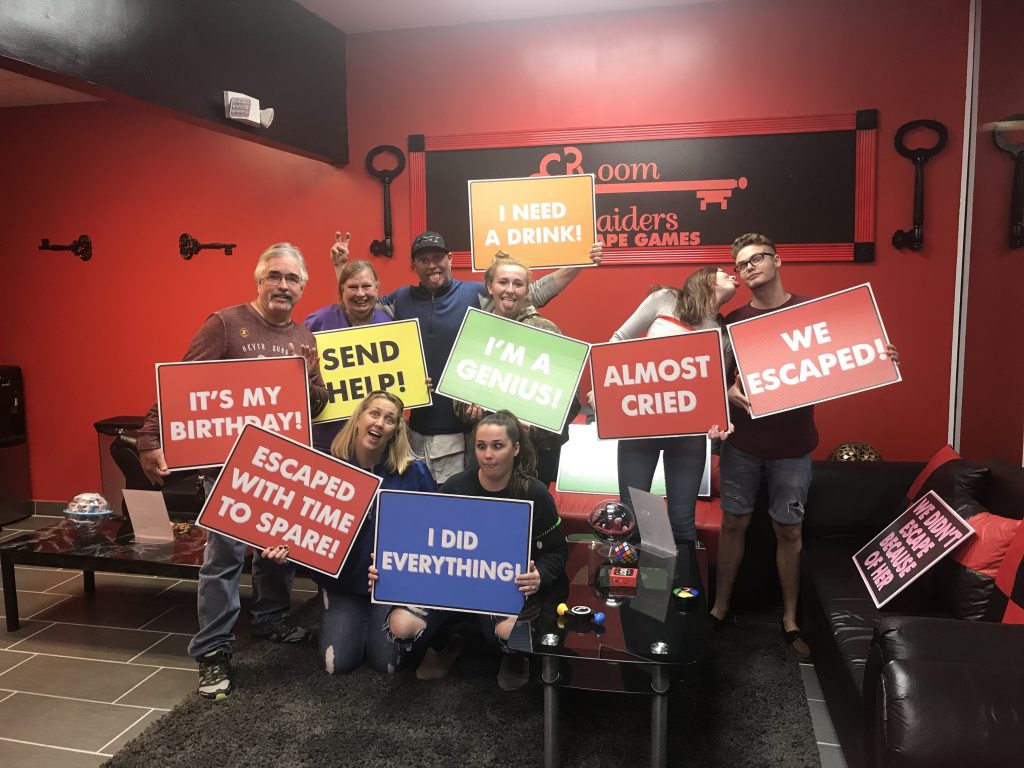 A group of people holding signs in front of a wall.