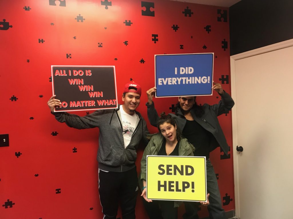 Three people holding signs in a room with stars on the wall.