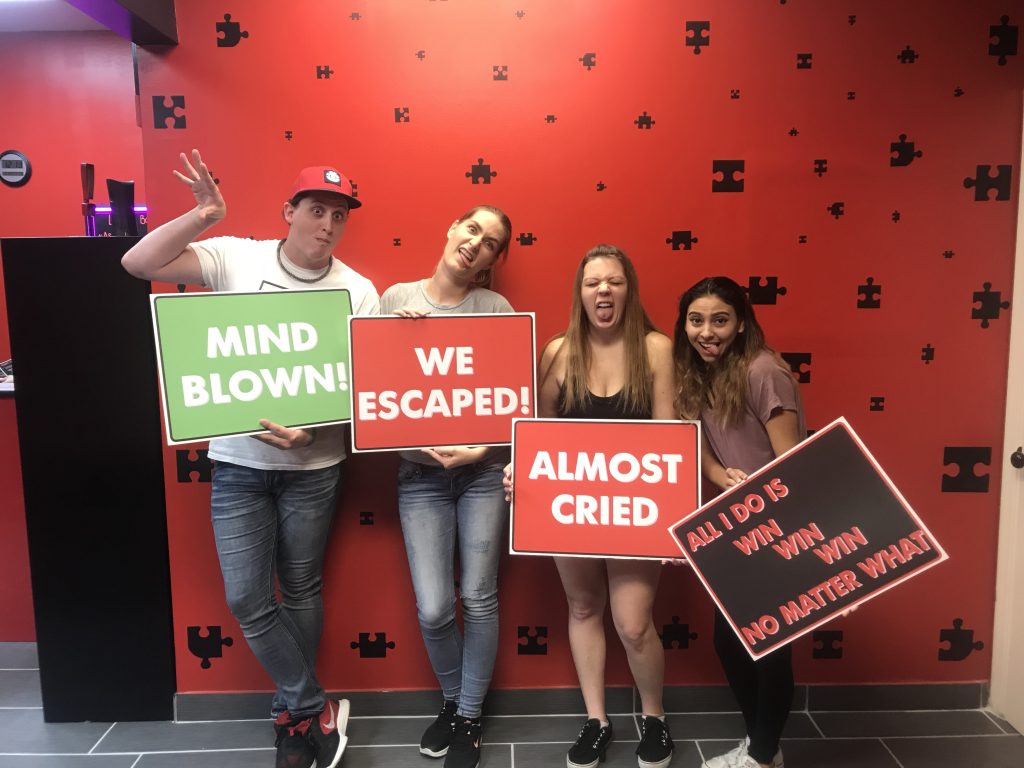 A group of people holding signs in front of a wall.