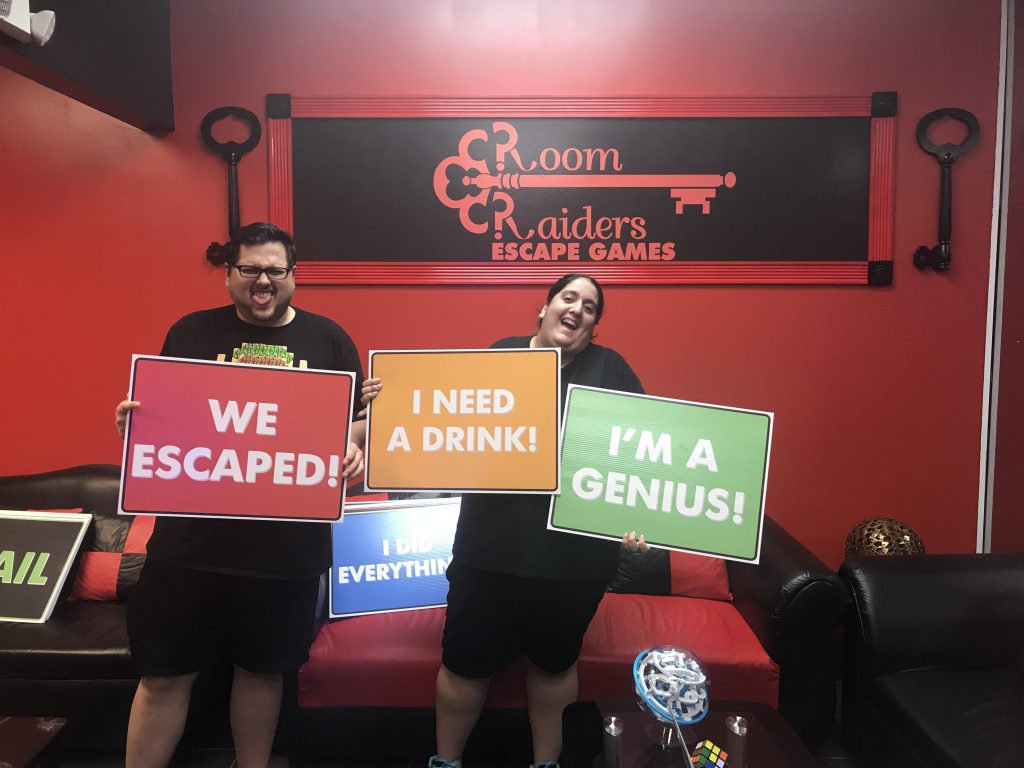 Three people holding signs in front of a room.