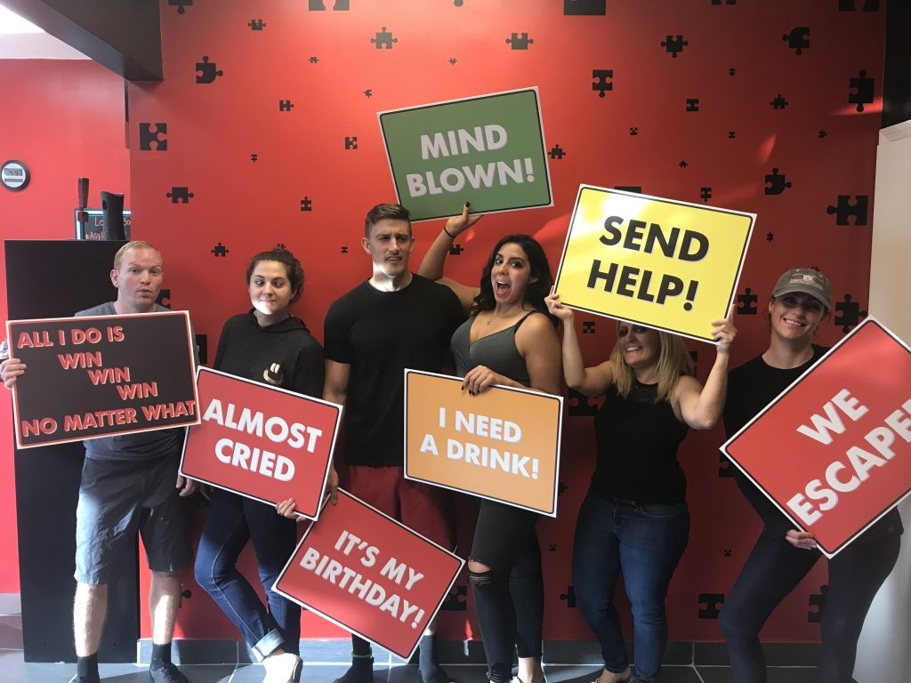 A group of people holding signs in front of a wall.