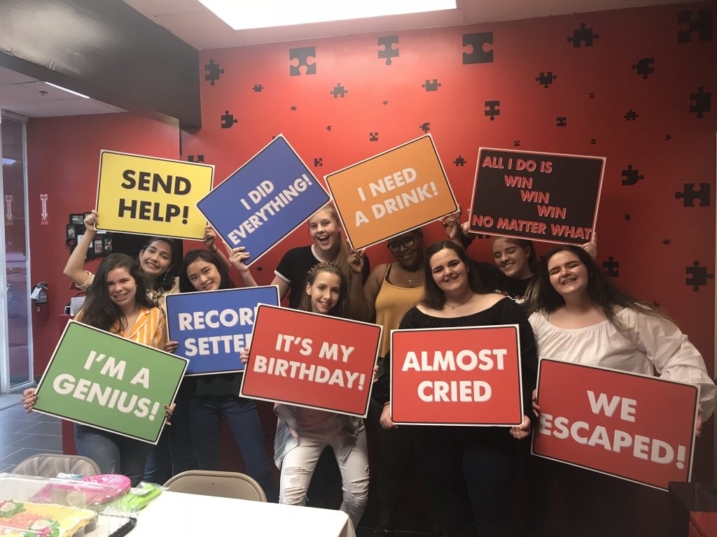 A group of people holding signs in front of a wall.