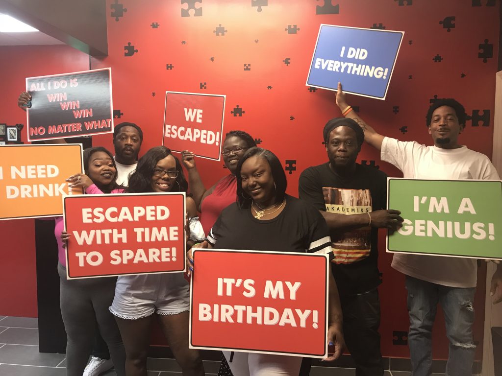 A group of people holding signs in front of a wall.