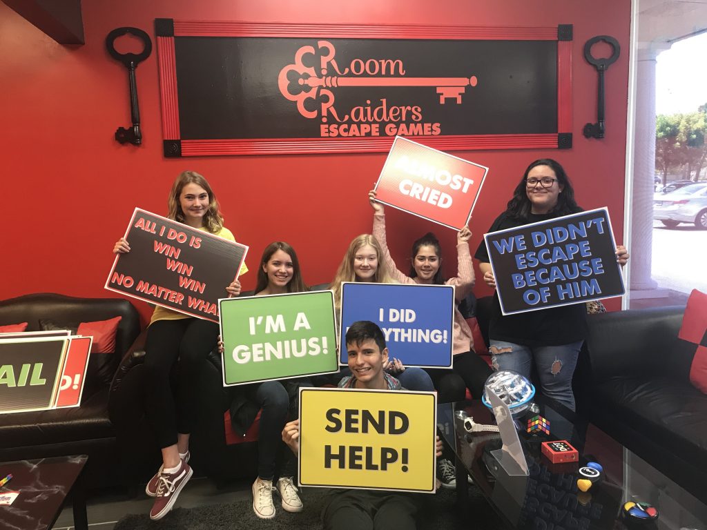 A group of people holding signs in front of a room.