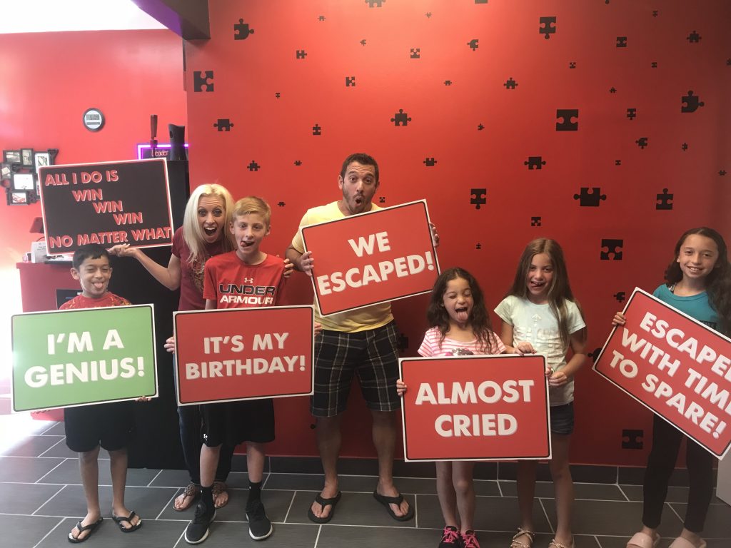 A group of people holding signs in front of a wall.