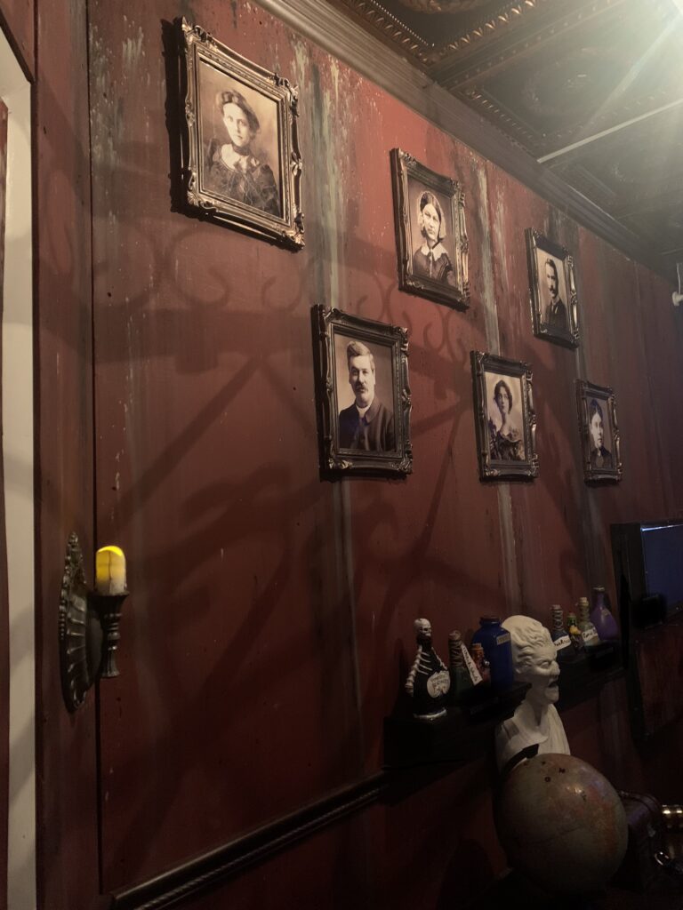 A person is standing in front of some pictures on the wall.